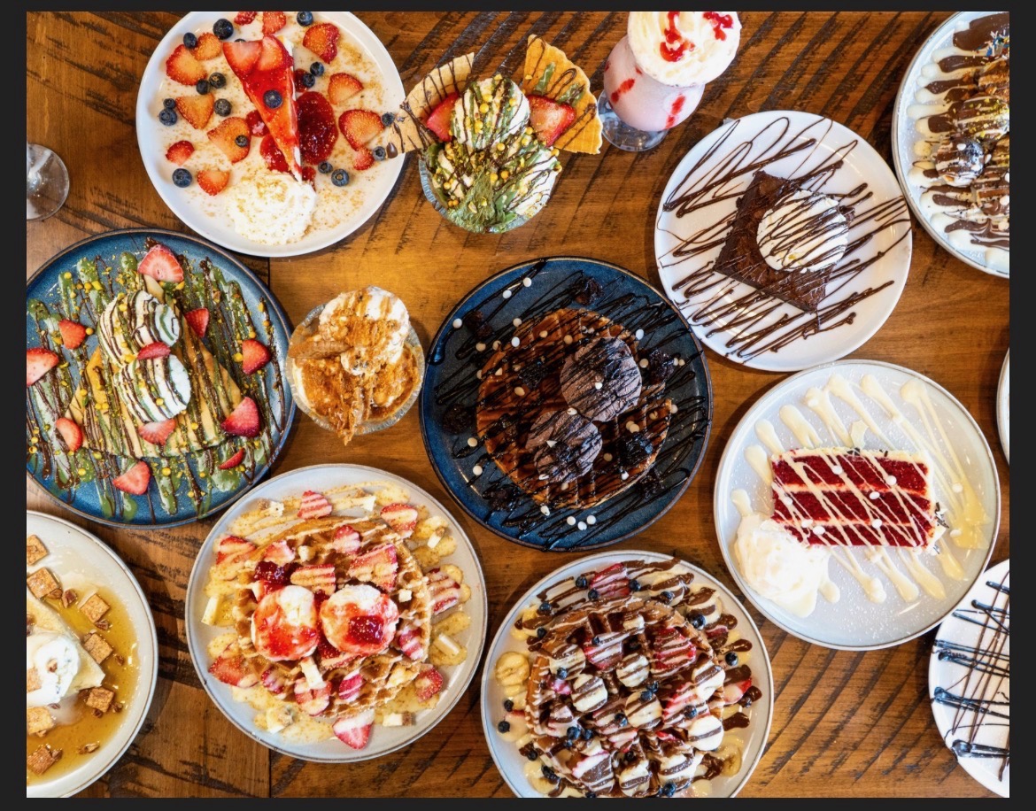 Overhead view of an assortment of Drizzora waffles, crepes, cakes and sundaes