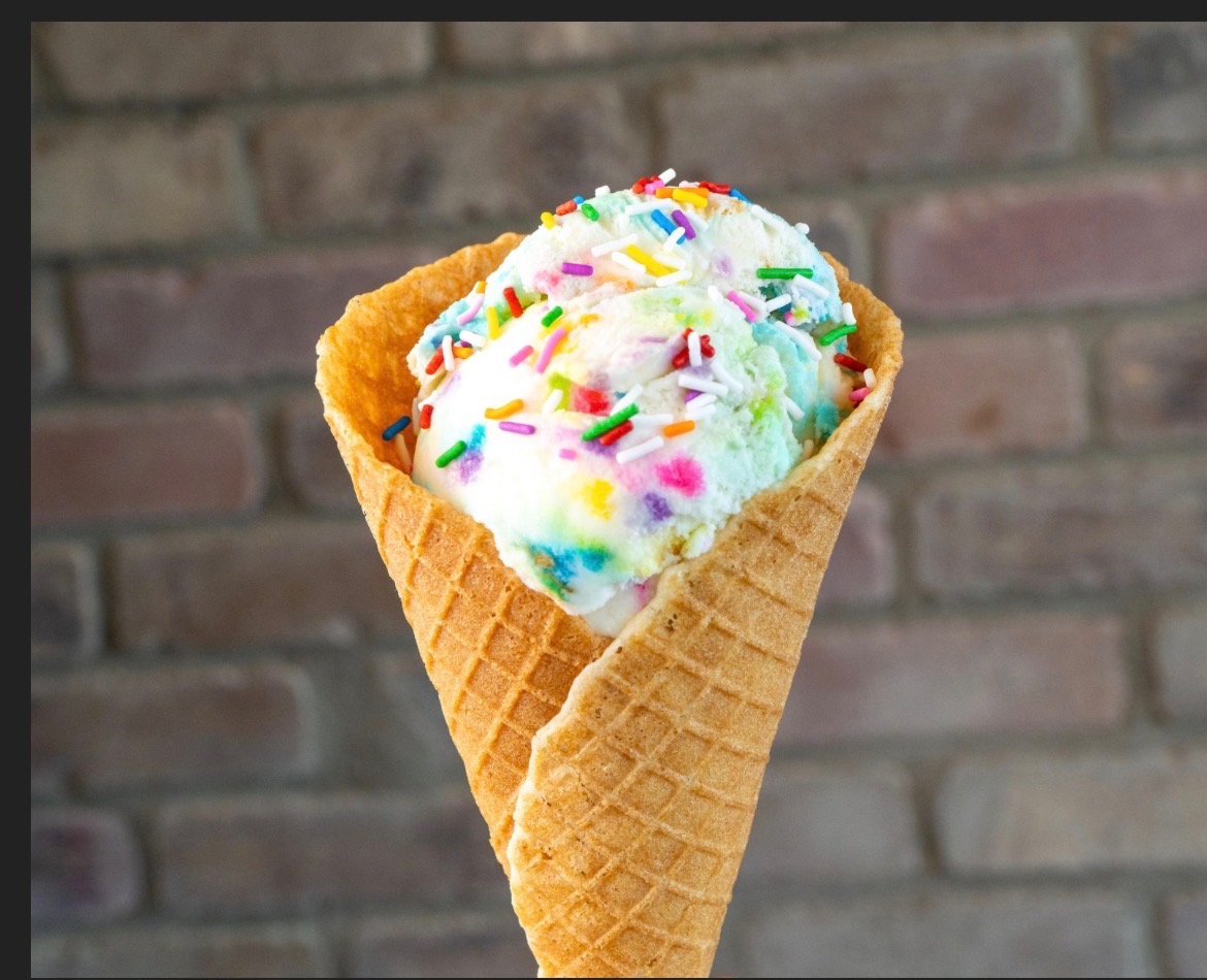 Birthday cake ice cream with rainbow sprinkles in a house-made waffle cone